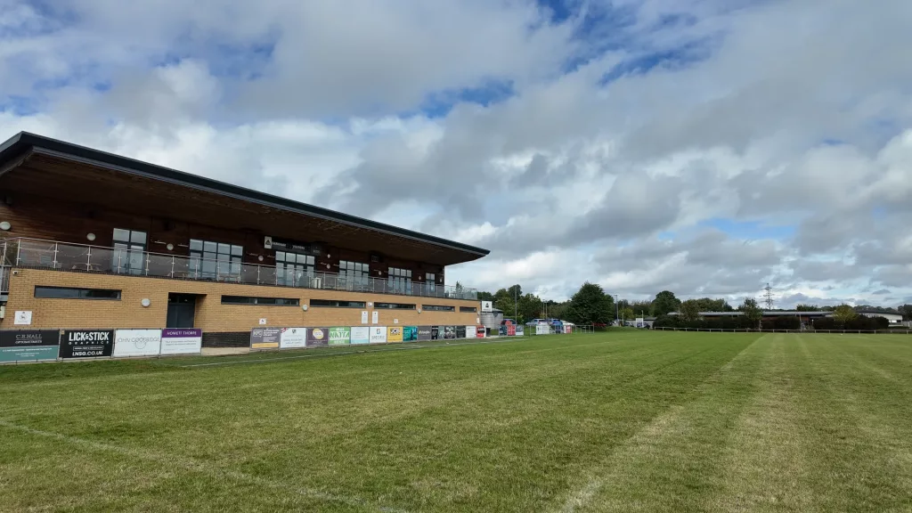 Farnham Rugby Club clubhouse and pitchside sponsor boards alongside the main pitch