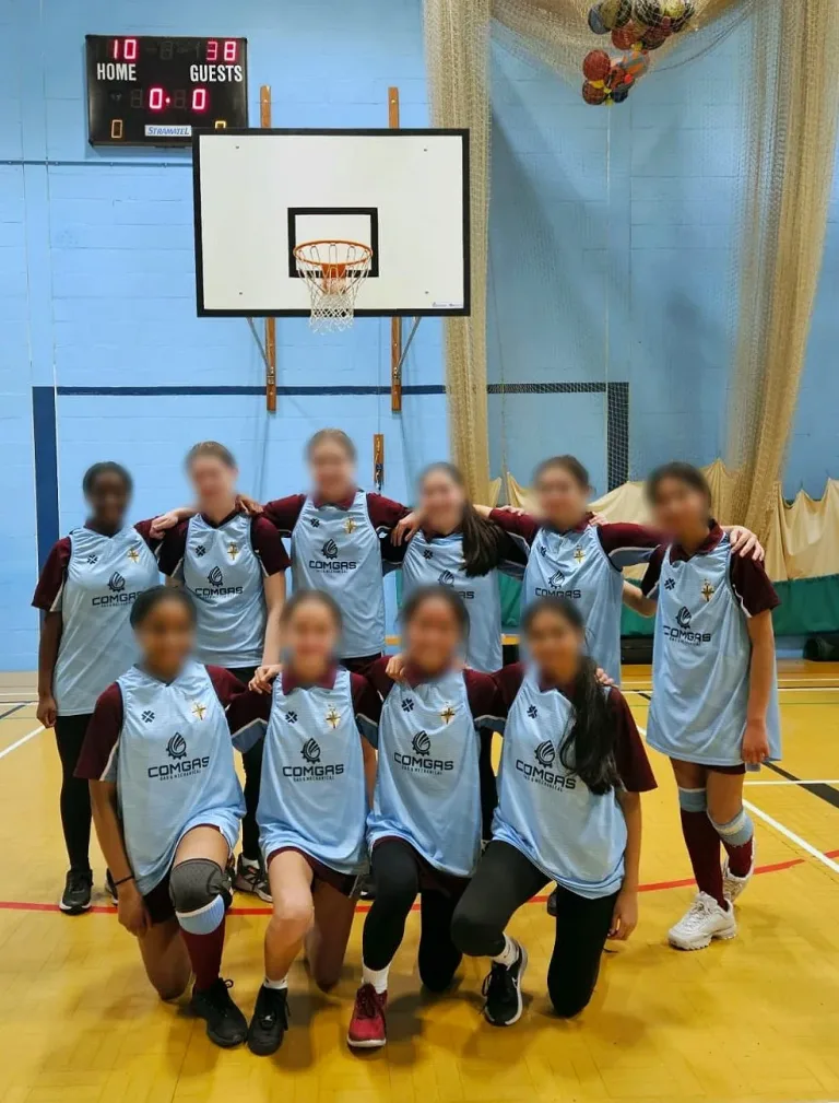 All Hallows Catholic School indoor sports team wearing ComGas-sponsored sky blue vests in the school sports hall