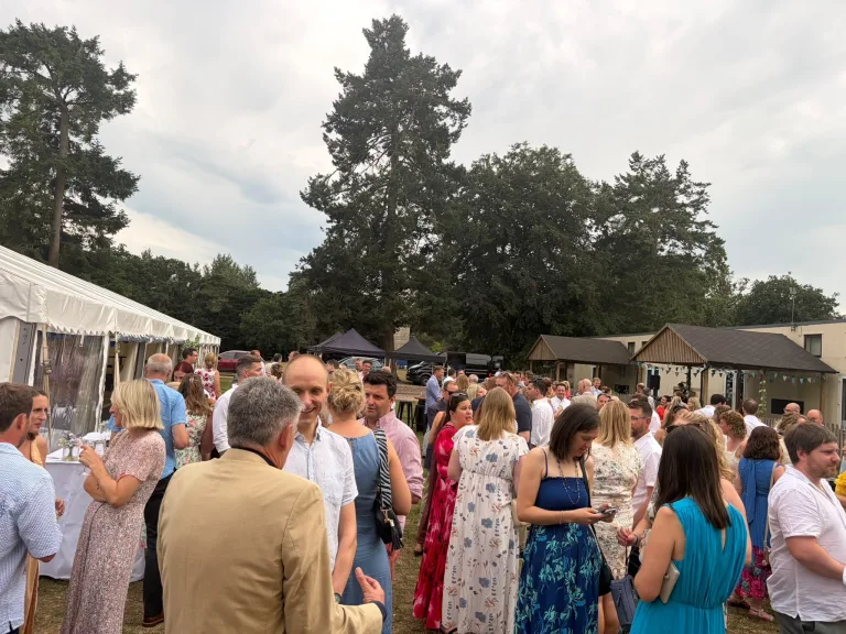 Guests in summer dress on the school grounds at the Barfield Summer Ball in Runfold