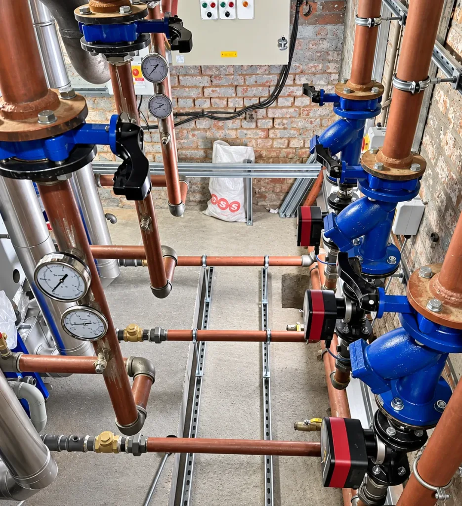 New circulating pumps, isolating valves and pressure gauges on the completed copper pipework