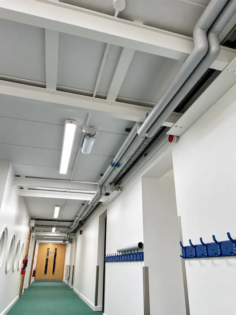 Corridor lighting and detection devices reinstated below high-level pipework