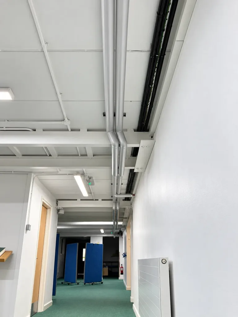 Corridor heating pipework and cable containment reinstated at high level alongside the new steel