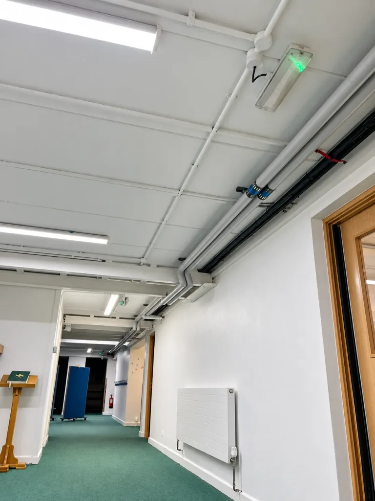 Corridor services with emergency lighting and a wall radiator returned to use
