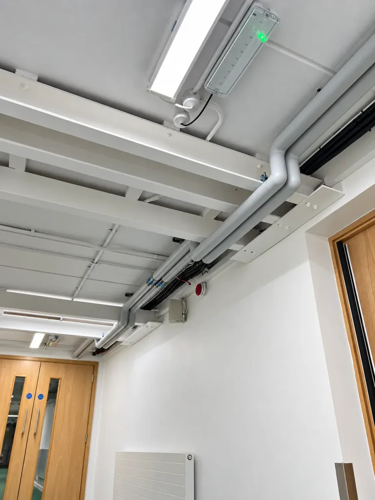 Heating pipework set out in an offset above a corridor doorway to clear the new steel