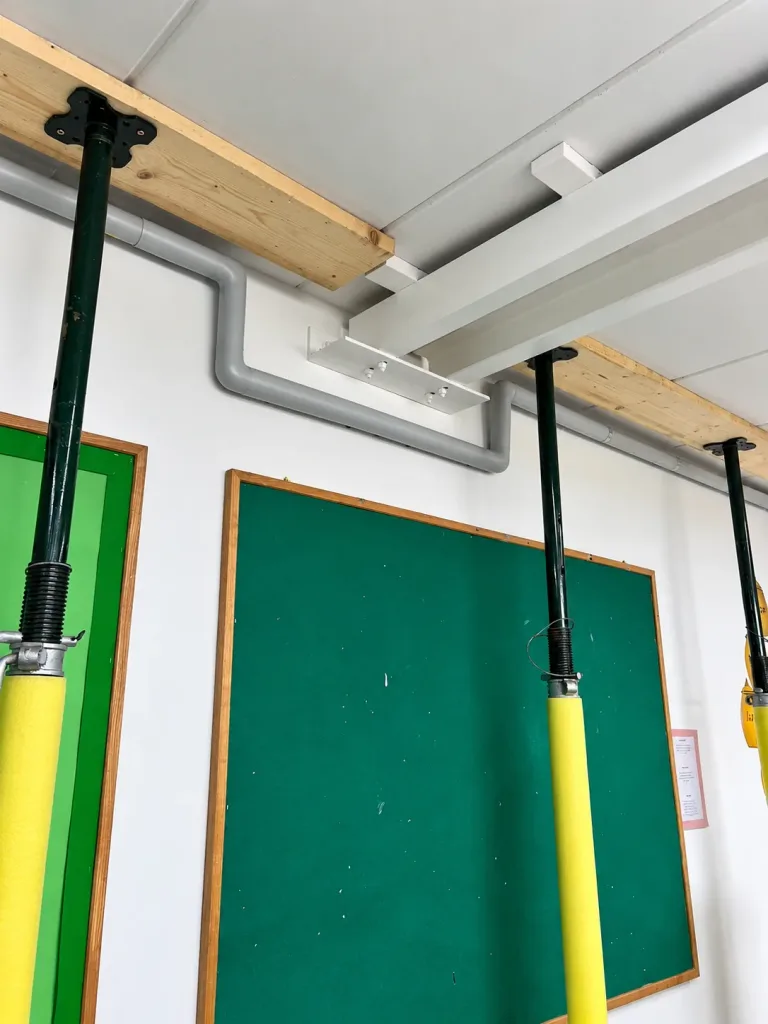 Temporary propping beneath the affected ceiling planks, with the heating main routed clear of the new steel support
