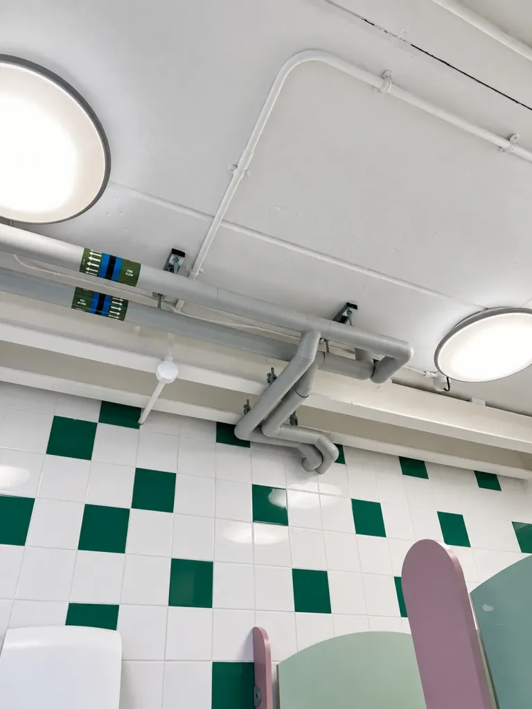 Domestic water and heating services reinstated at ceiling level in a school WC area