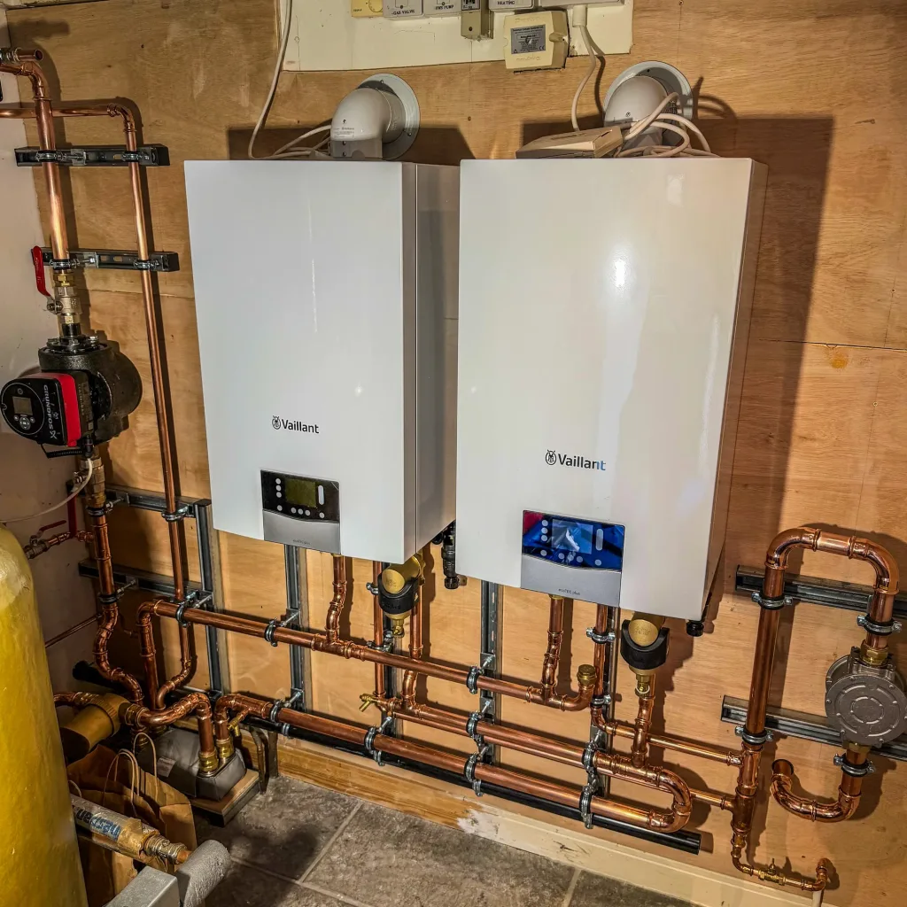The two new Vaillant boilers at first fix, with new copper primary pipework, isolation valves and pipe supports in place before insulation