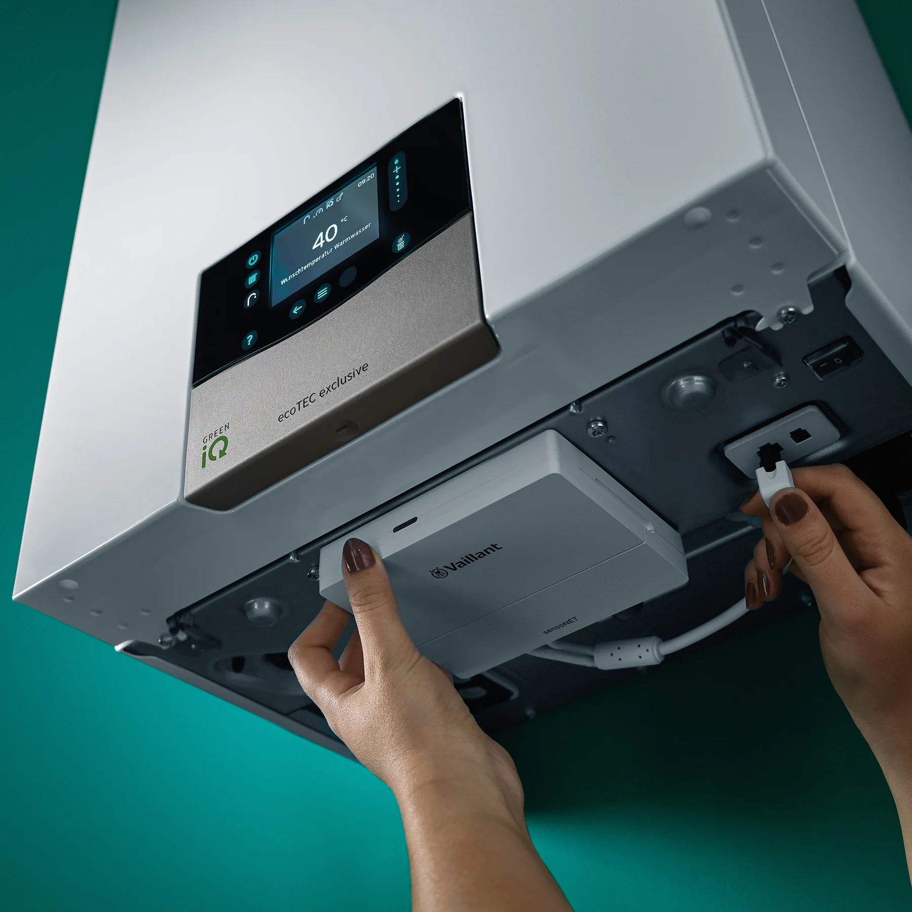 Vaillant ecoTEC exclusive gas boiler with its casing open and a component being refitted during a service