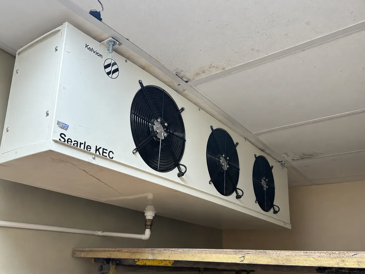 Existing three-fan indoor blower coil within the cold-room area.